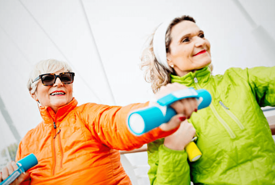 Elderly ladies exercising with light hand held weights. 
