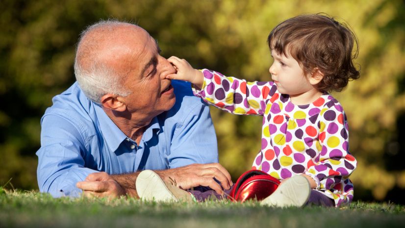 Image of an elderly man playing with his grandchild