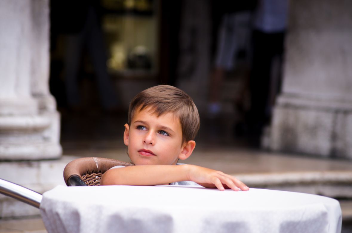Explaining Dementia to children | Image of a boy sat at a table outside