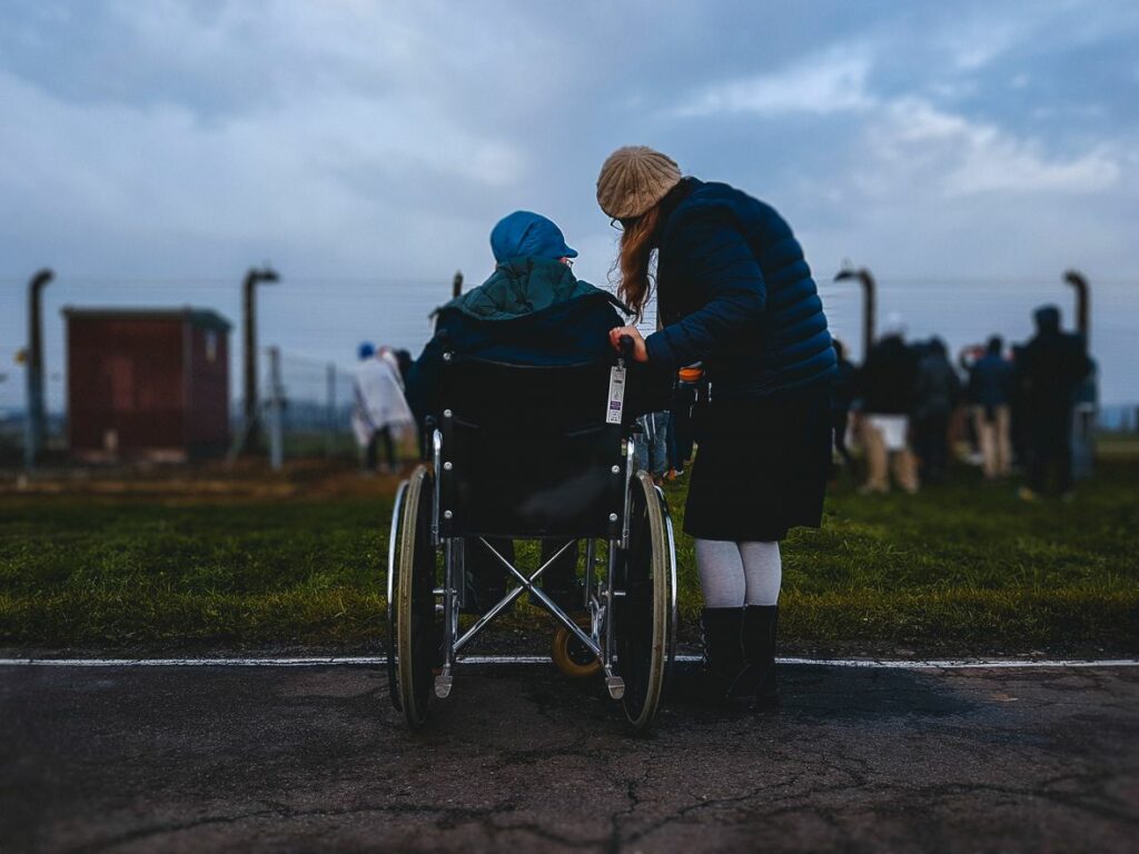 exercise for elderly with limited mobility | image of a man in a wheelchair with a carer
