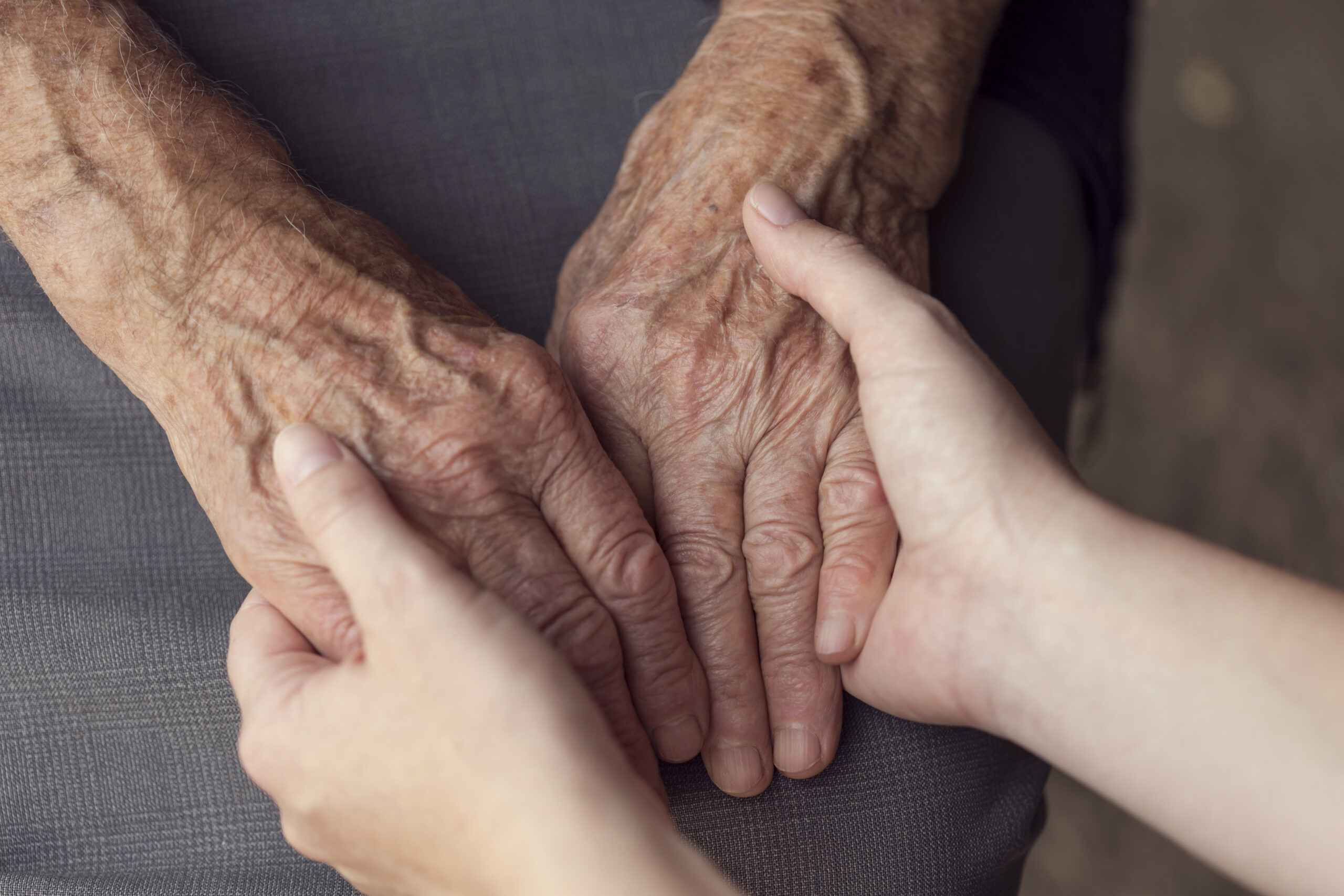 young hands holding elderly hands | Caring for someone with Dementia