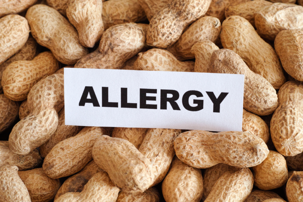 Image of an "Allergy" sign on a pile of peanuts