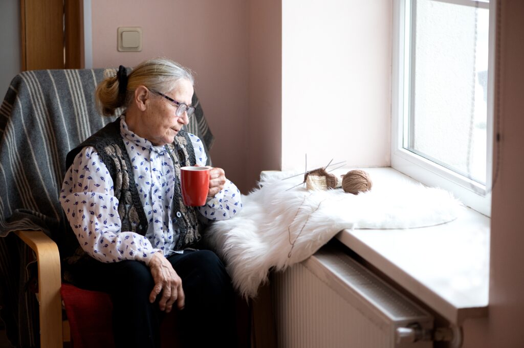 Elderley lady sitting at window with seasonal depression - care in kent