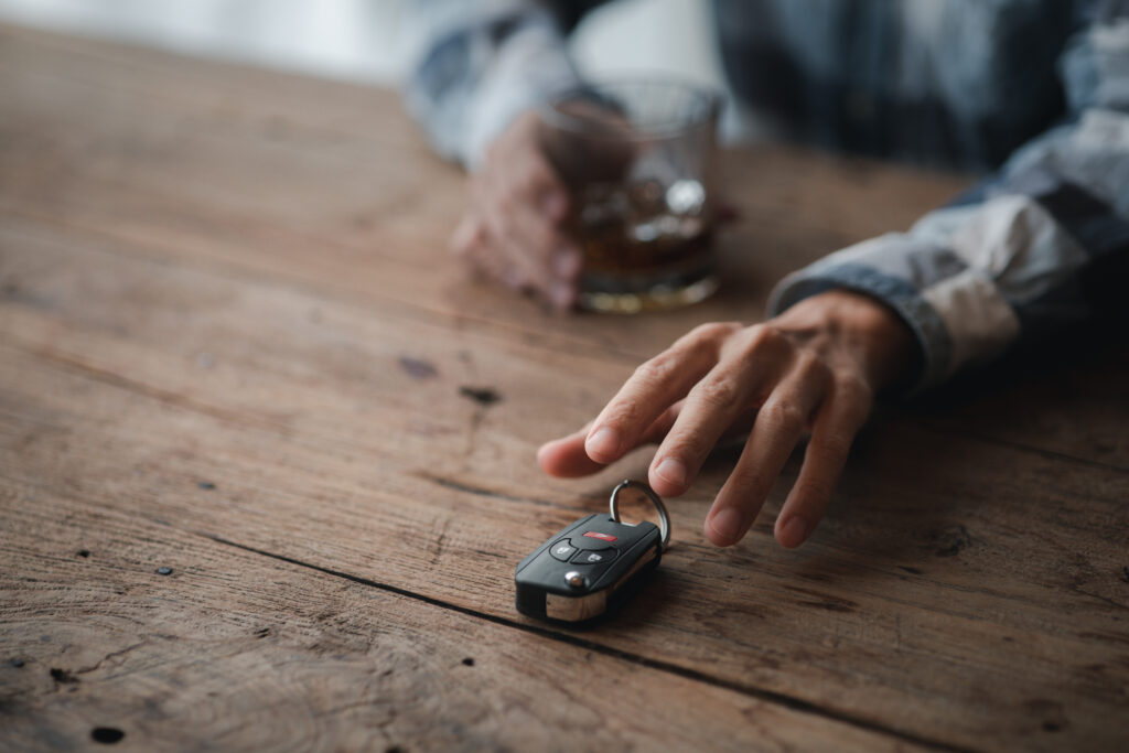 A thoughtful elderly person looking at their car keys on the table, contemplating the future without driving. Alt text: "Elderly individual contemplating the emotional significance of driving and the transition towards relinquishing their license."